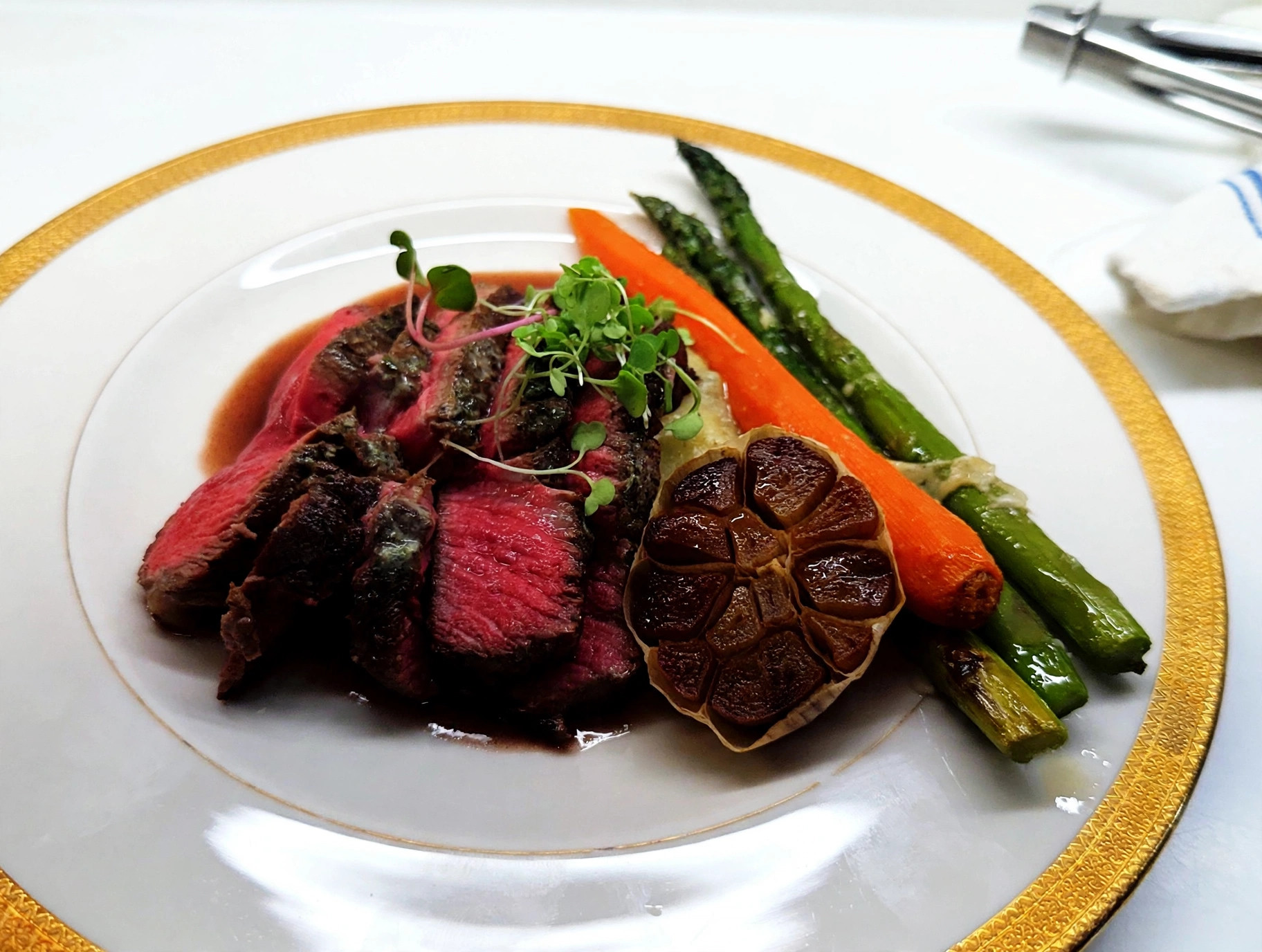 Sliced beef tenderloin with asparagus, roasted carrot and roasted garlic