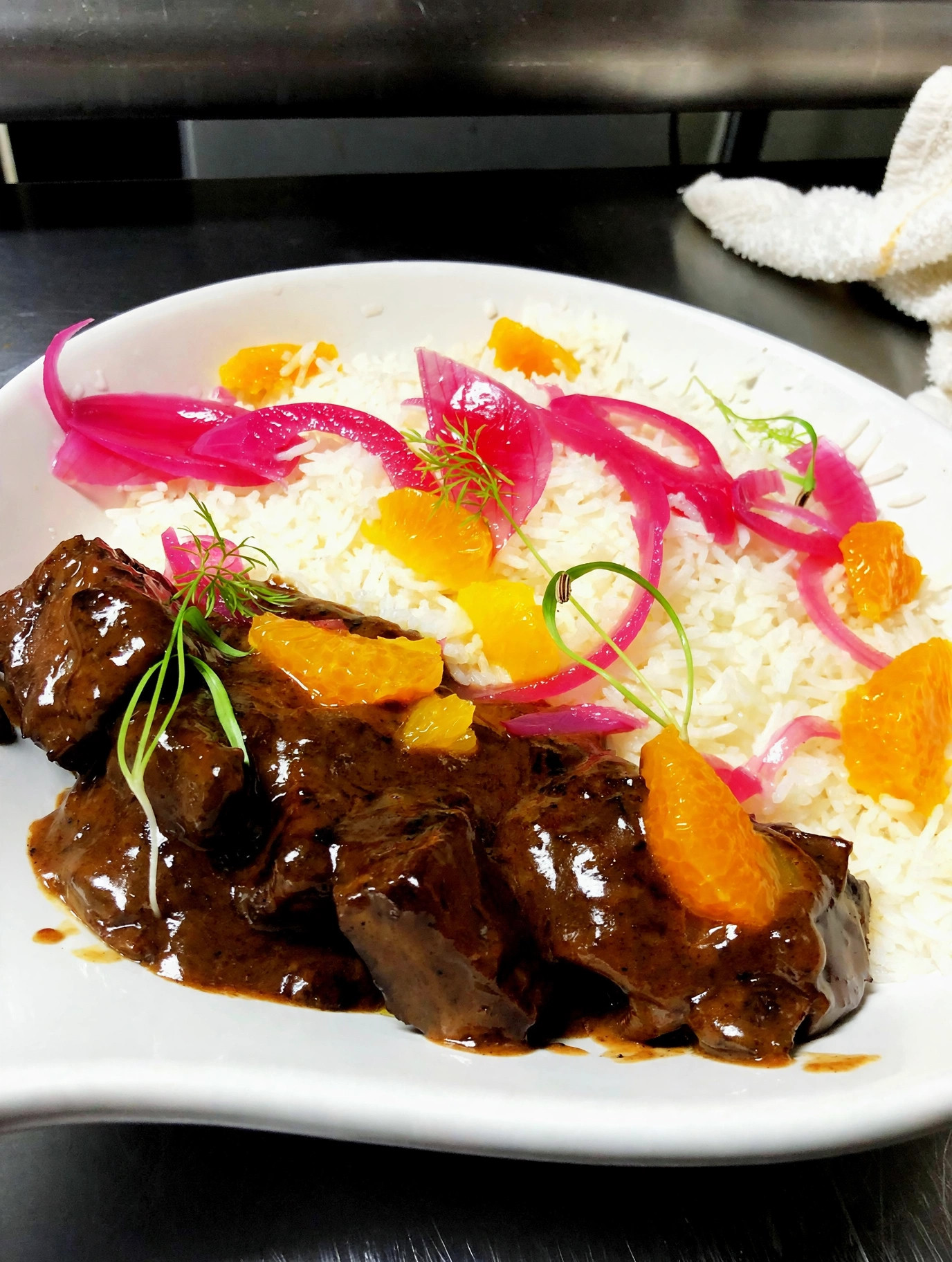 Braised beef with rice, pickled onions and orange