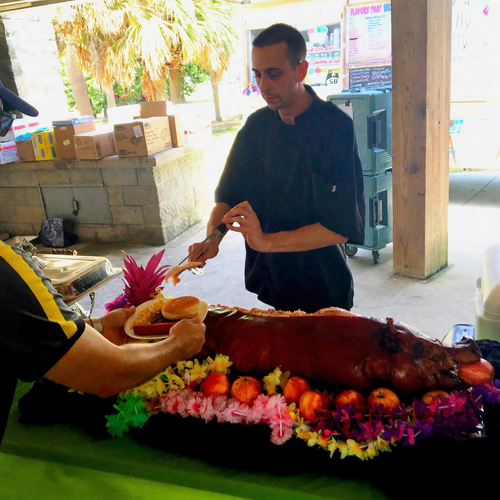 Chef Tony carving a whole roasted pig at an outdoor event